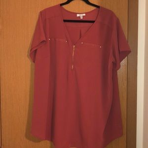 Coral colored blouse with gold zipper.